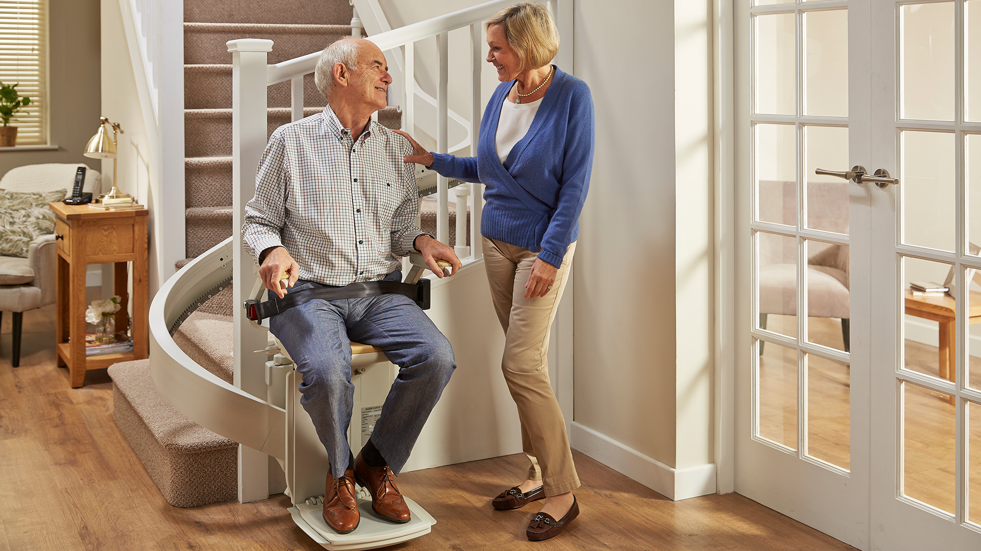 A couple beside a stairlift in their home